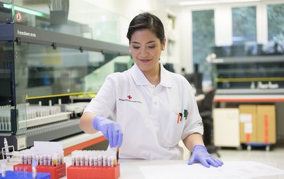 Eine Rotkreuz-Mitarbeiterin bei der Labordiagnostik testet das Spender_innenblut.
